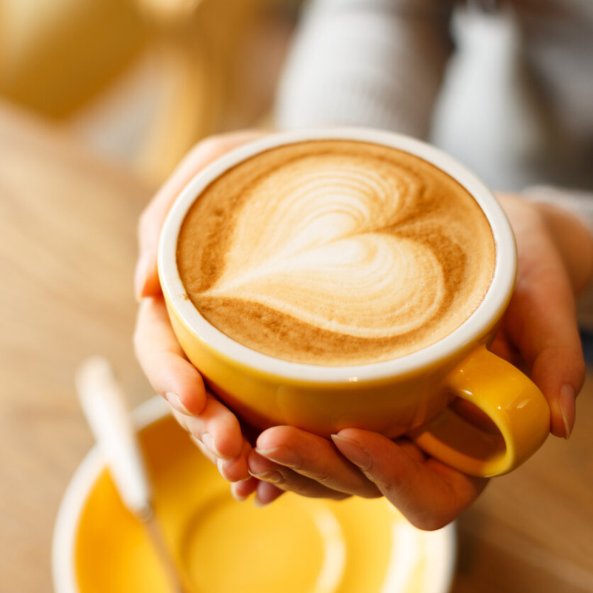lady's hands holding cup with sth heart-shaped lady's hands hold cup filled with something heart-shaped